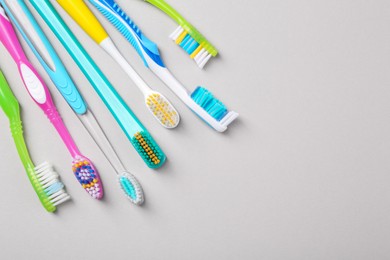 Photo of Many different toothbrushes on light background, flat lay. Space for text