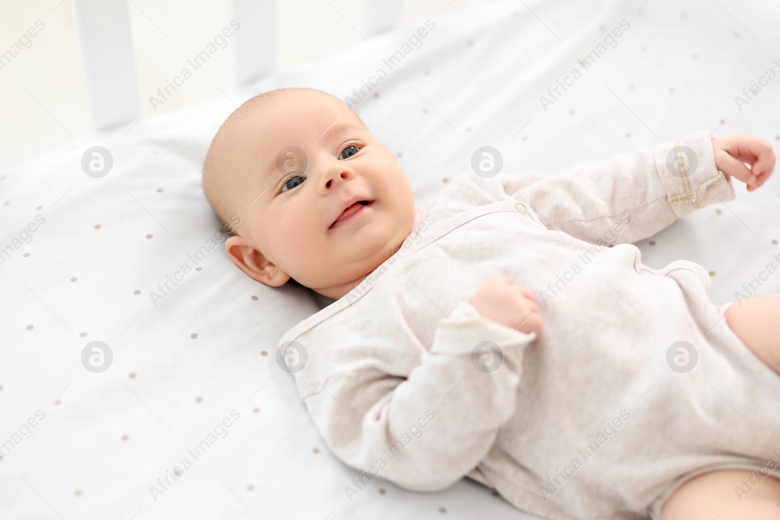 Photo of Cute little baby lying in crib at home