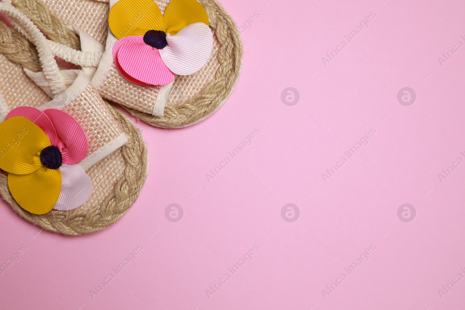 Photo of Cute baby shoes on pink background, flat lay. Space for text