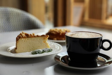 Photo of Cup of fresh coffee and desserts on table indoors
