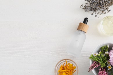 Flat lay composition with bottle of cosmetic oil on white wooden table, space for text