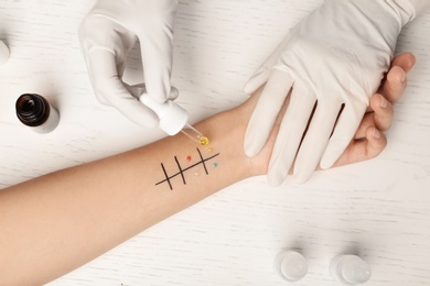 Photo of Doctor making allergy test at table, top view