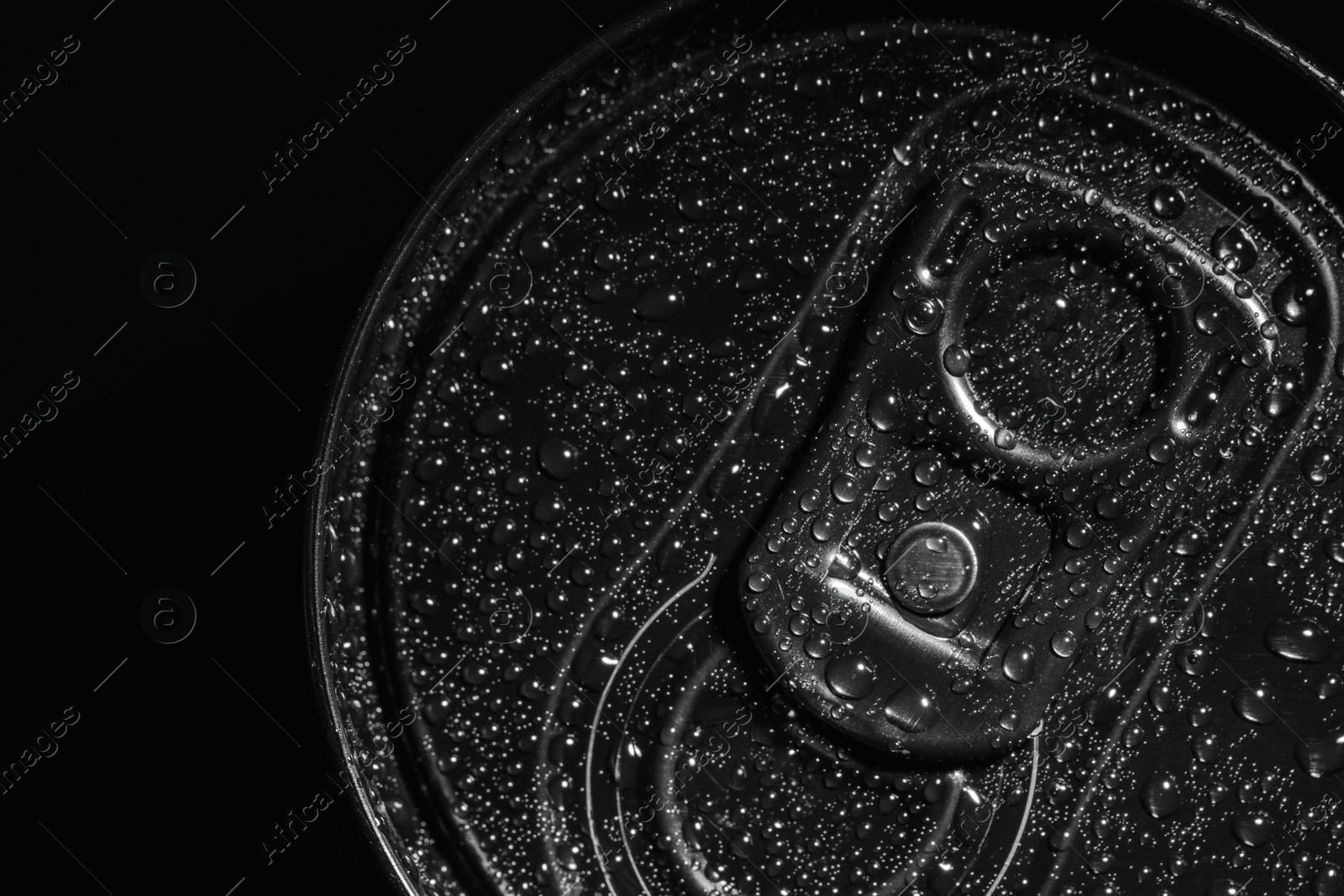Photo of Aluminum can of beverage covered with water drops on black background, top view