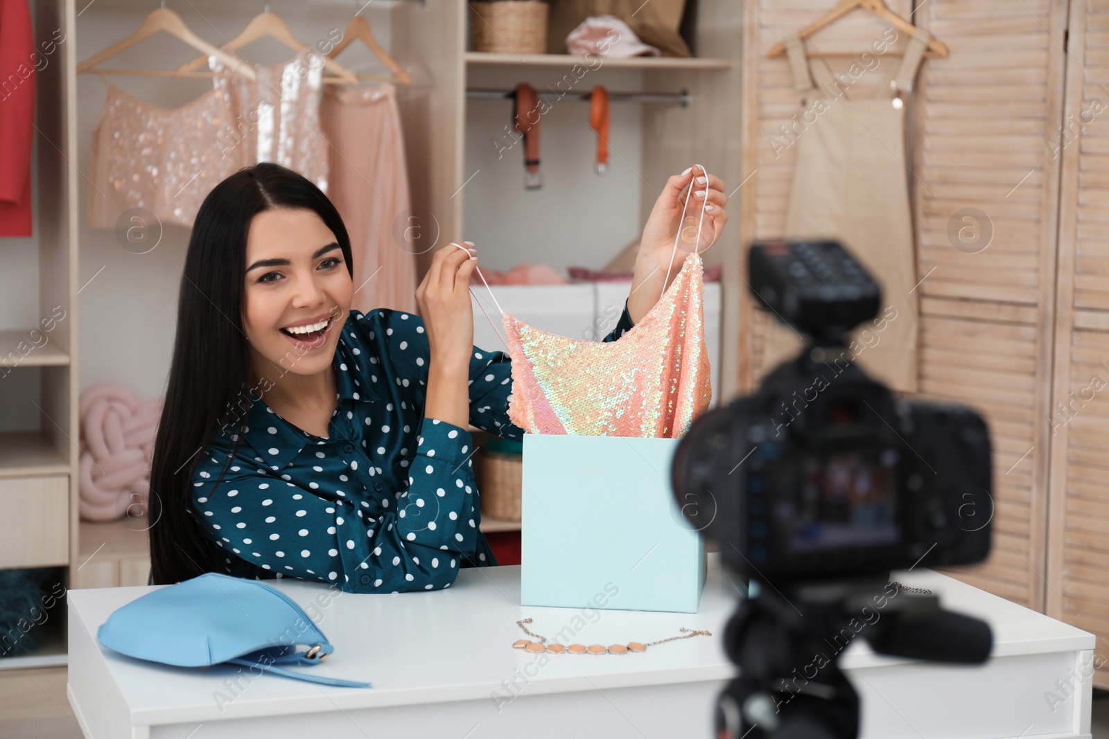 Photo of Fashion blogger recording new video at table indoors