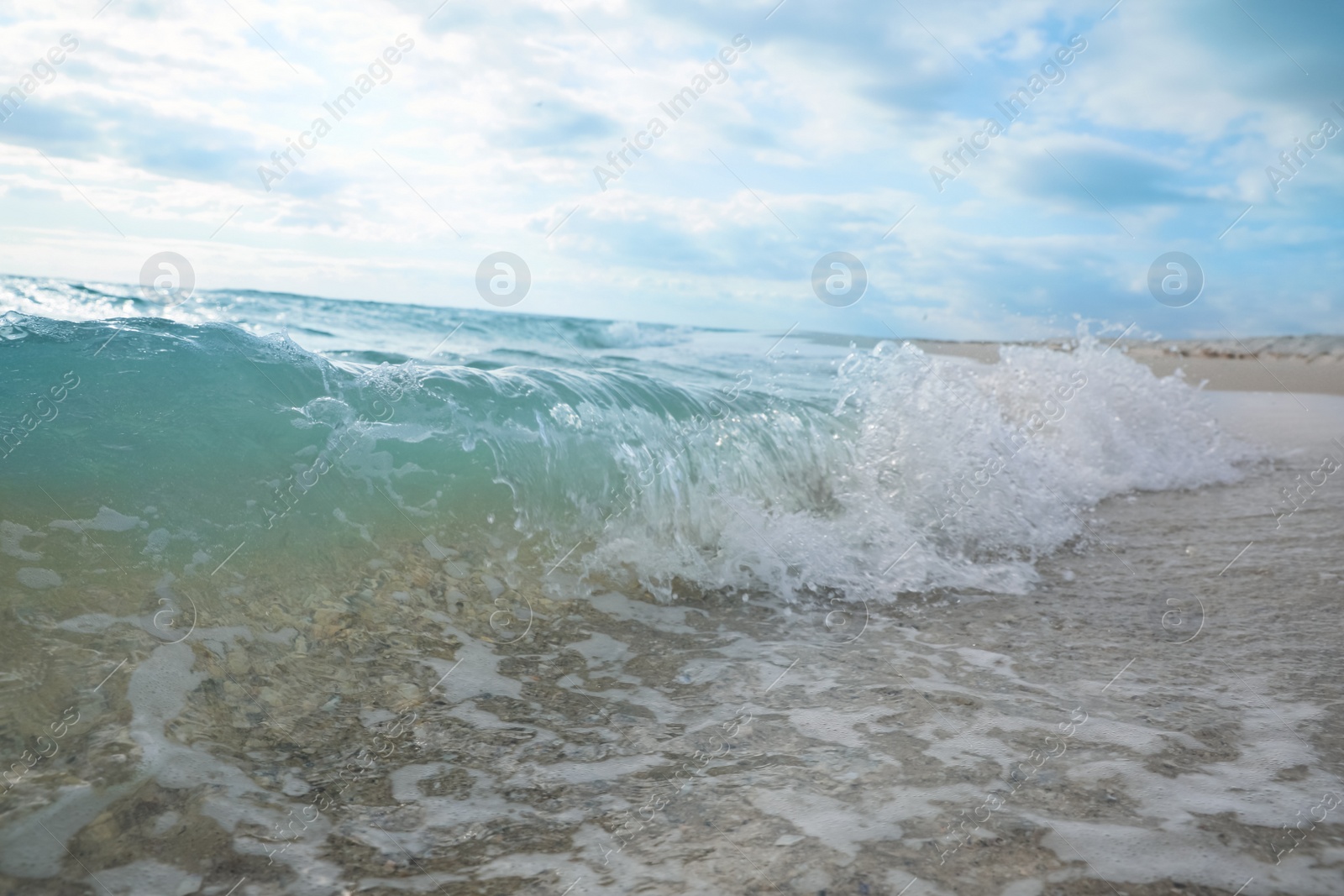 Photo of Turquoise sea waves rolling onto tropical beach