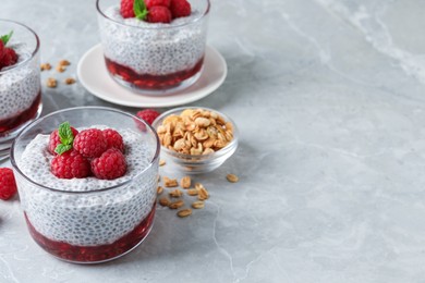 Delicious chia pudding with raspberries and mint on light marble table, space for text