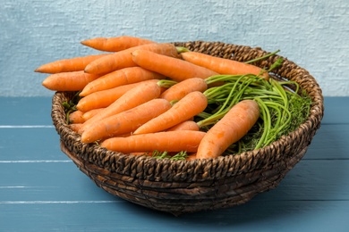 Bowl with ripe carrots on wooden table