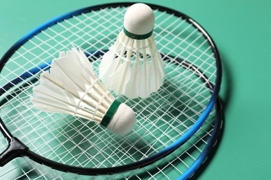 Feather badminton shuttlecocks and rackets on green background, closeup