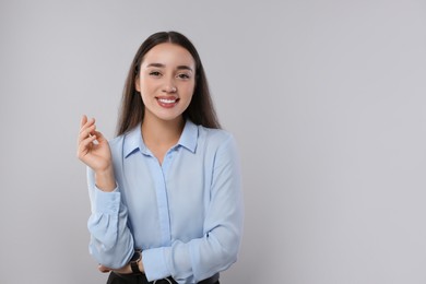 Portrait of beautiful young woman on light grey background. Space for text