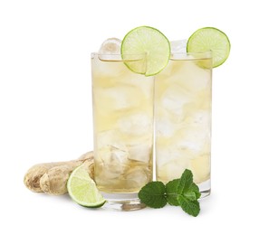 Photo of Glasses of tasty ginger ale with ice cubes and ingredients isolated on white