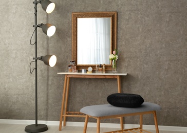 Stylish room interior with set of makeup products on dressing table