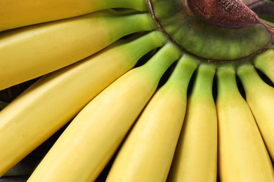Photo of Bunch of tasty ripe baby bananas as background, closeup