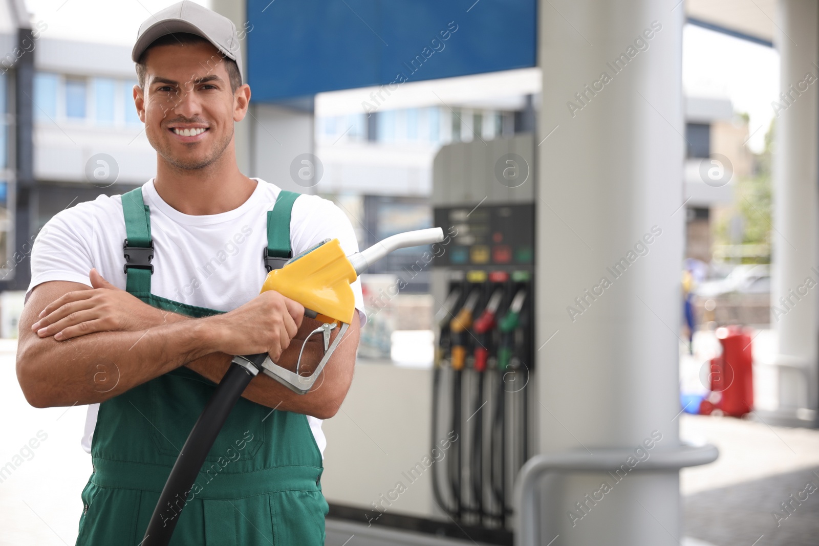 Photo of Worker with fuel pump nozzle at modern gas station