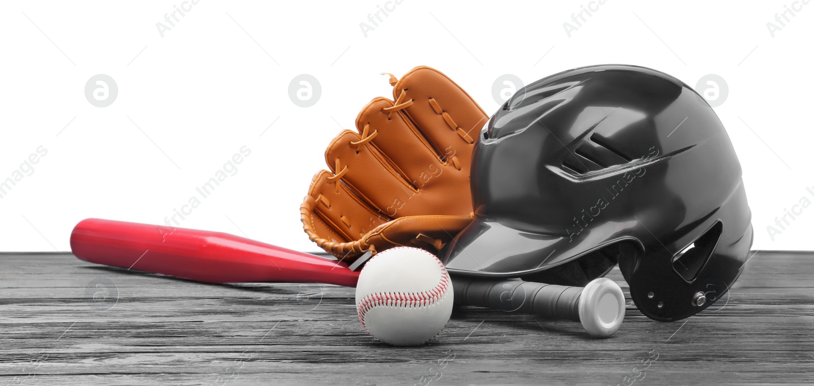 Photo of Baseball glove, bat, ball and batting helmet on dark wooden table against white background