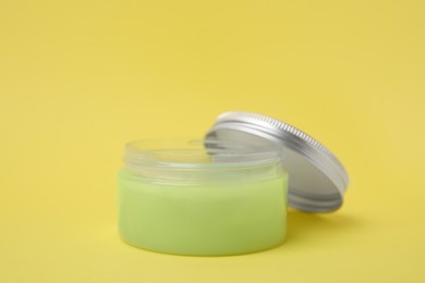 Jar of petroleum jelly on yellow background