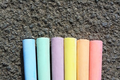 Colorful chalk sticks on asphalt, flat lay. Space for text