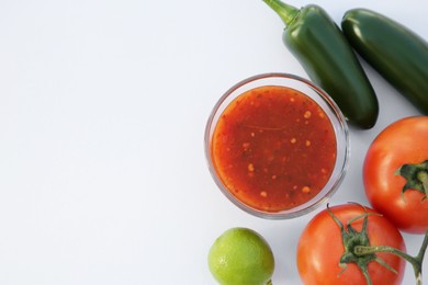 Bowl with delicious salsa sauce and ingredients on white background, flat lay. Space for text