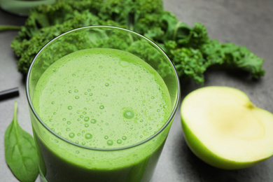 Photo of Tasty fresh kale smoothie on grey table, closeup