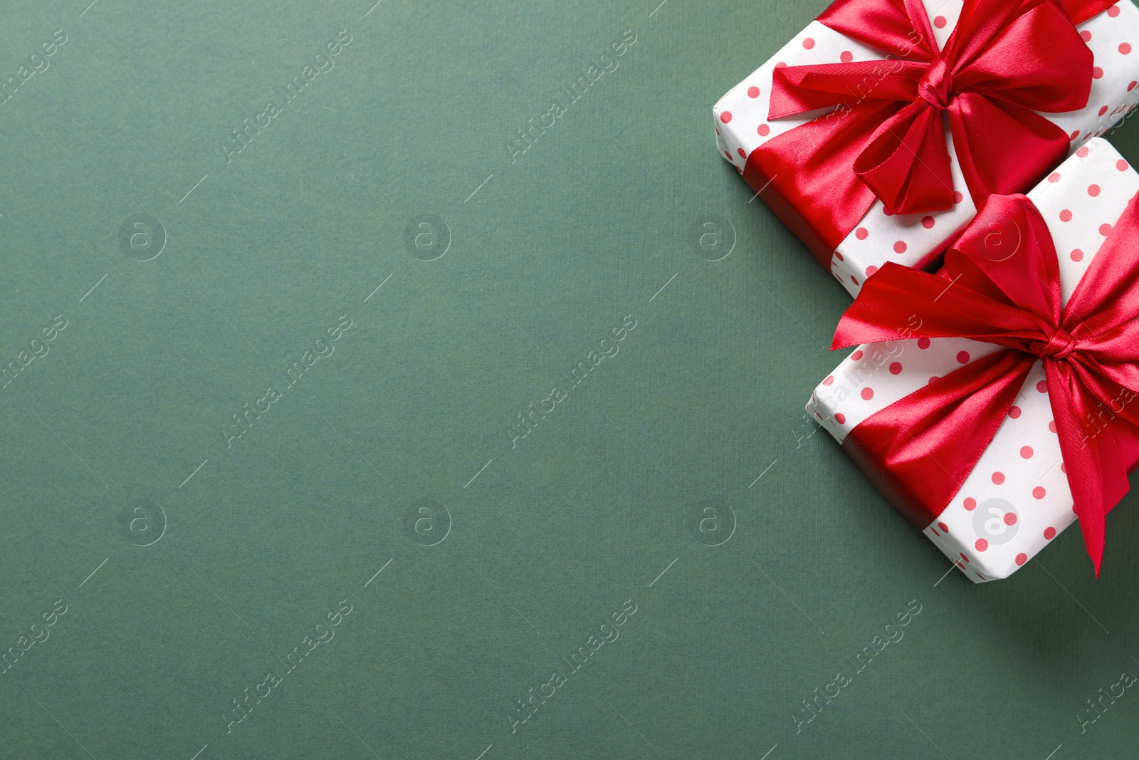 Photo of Beautifully wrapped gift boxes on color background, top view