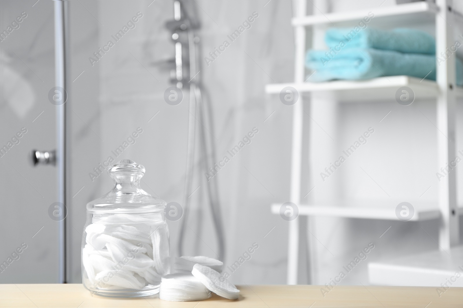 Photo of Cotton pads on wooden table in bathroom