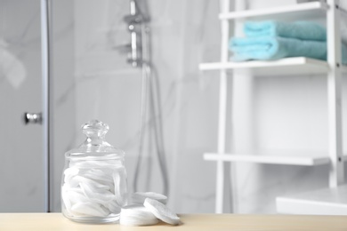 Cotton pads on wooden table in bathroom