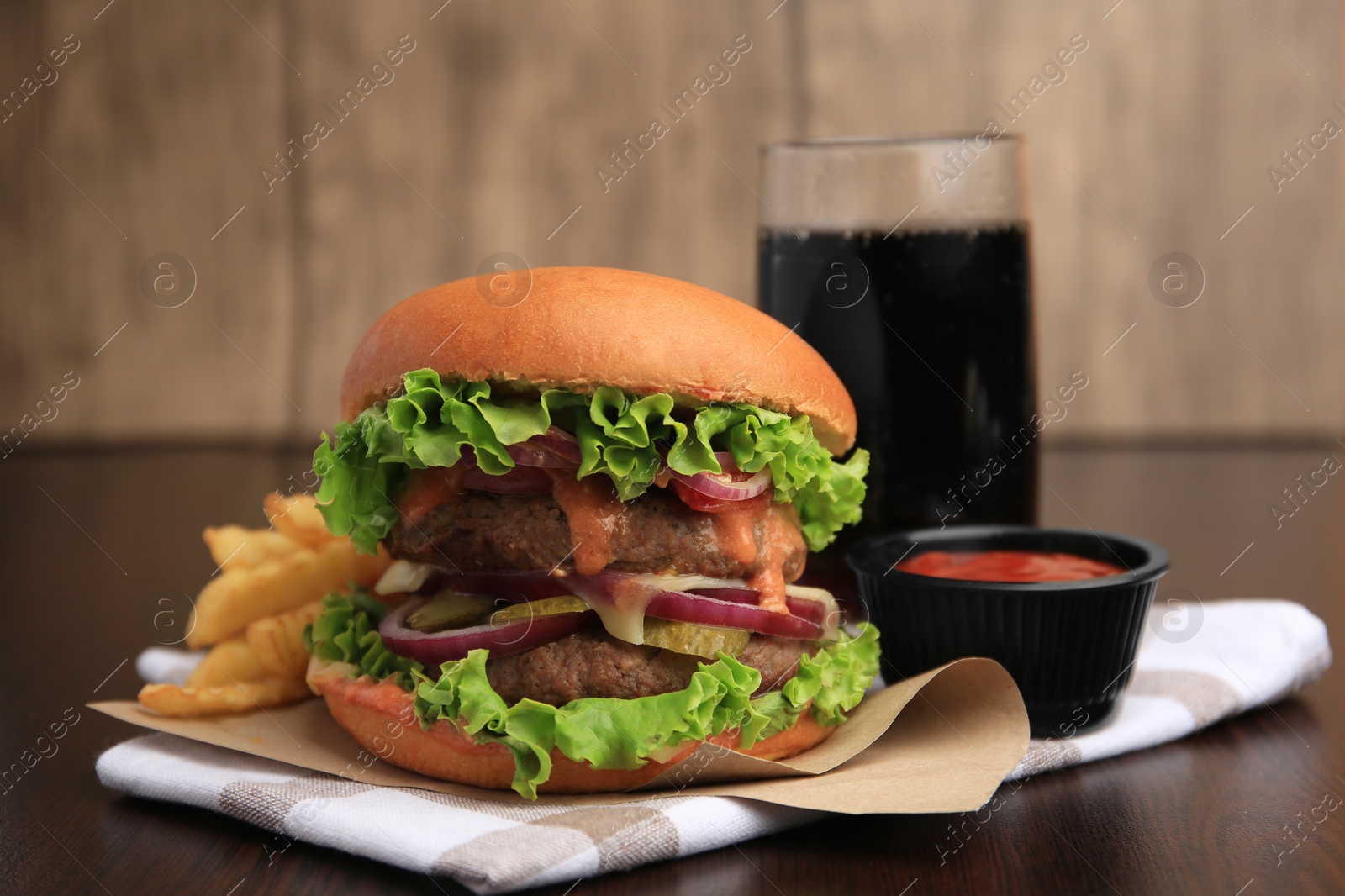Photo of Tasty burger with vegetables, patties and lettuce served on wooden table