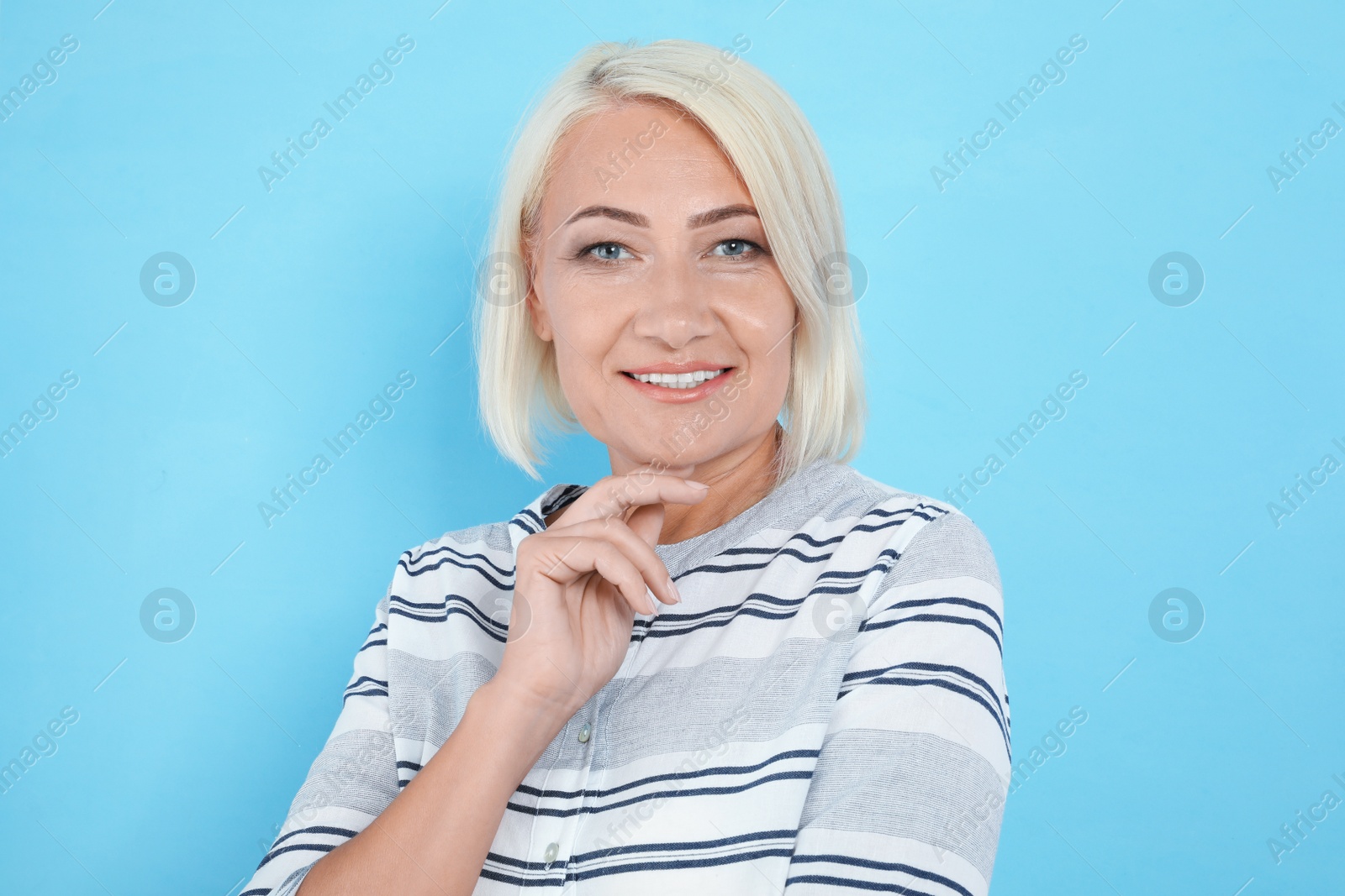 Photo of Portrait of mature woman with beautiful face on light blue background
