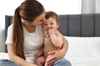 Photo of Mother kissing with her baby on bed at home