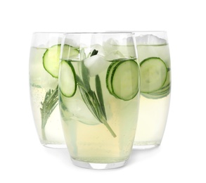 Photo of Glasses of refreshing cucumber lemonade and rosemary on white background. Summer drink