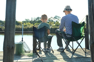 Father and son fishing together on sunny day