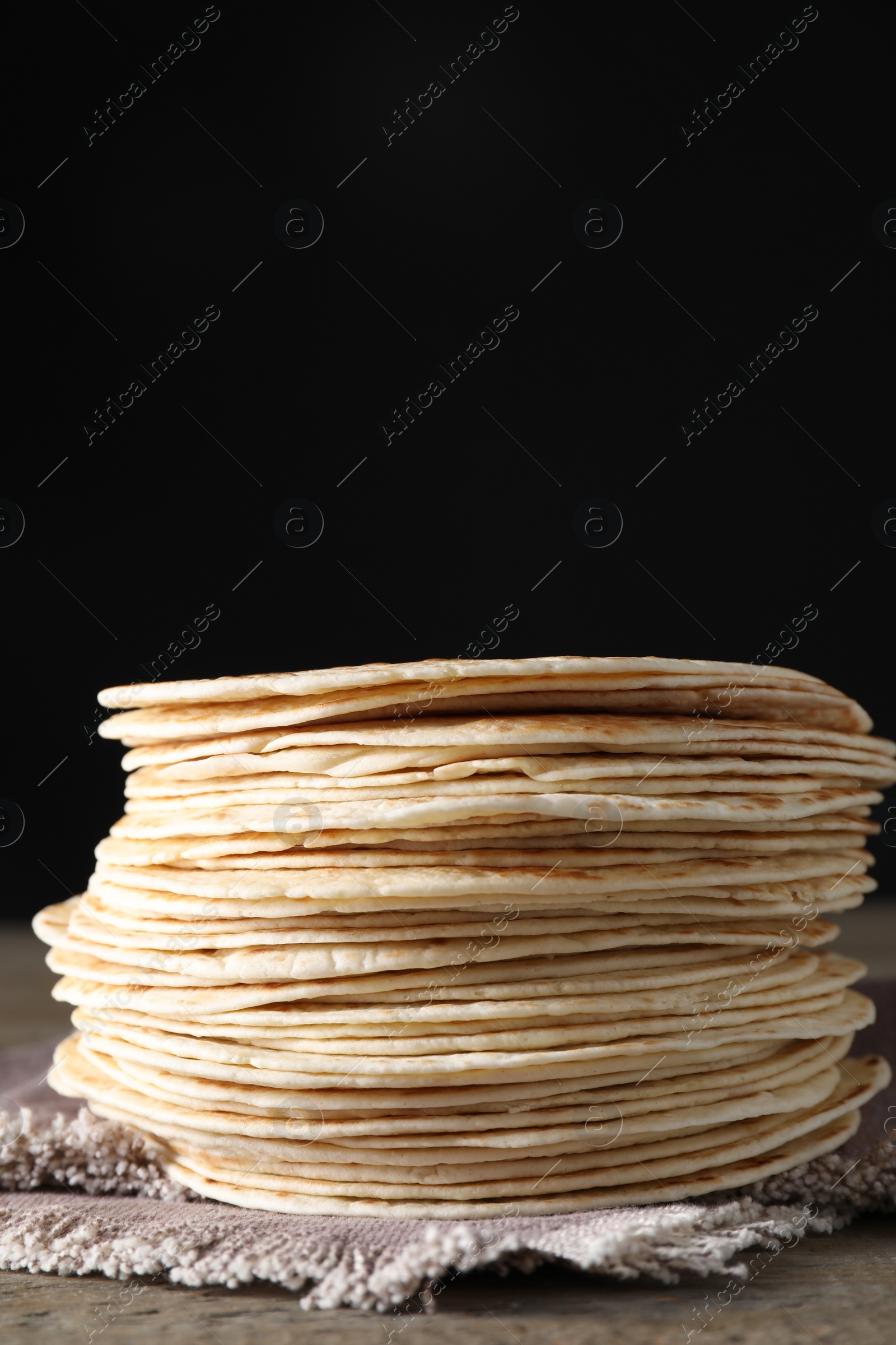 Photo of Many tasty homemade tortillas on wooden table, space for text