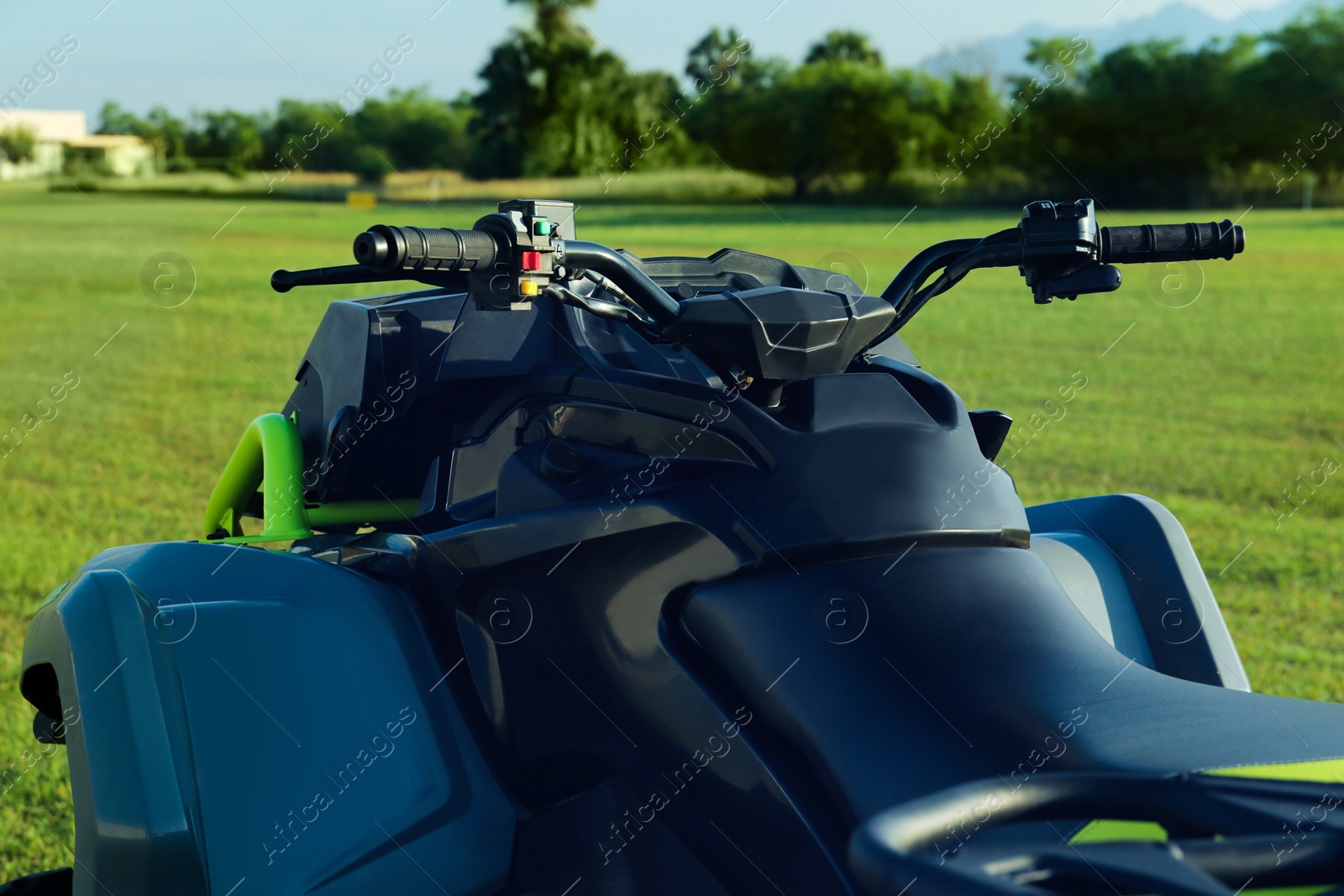 Photo of Modern quad bike in field on sunny day, closeup