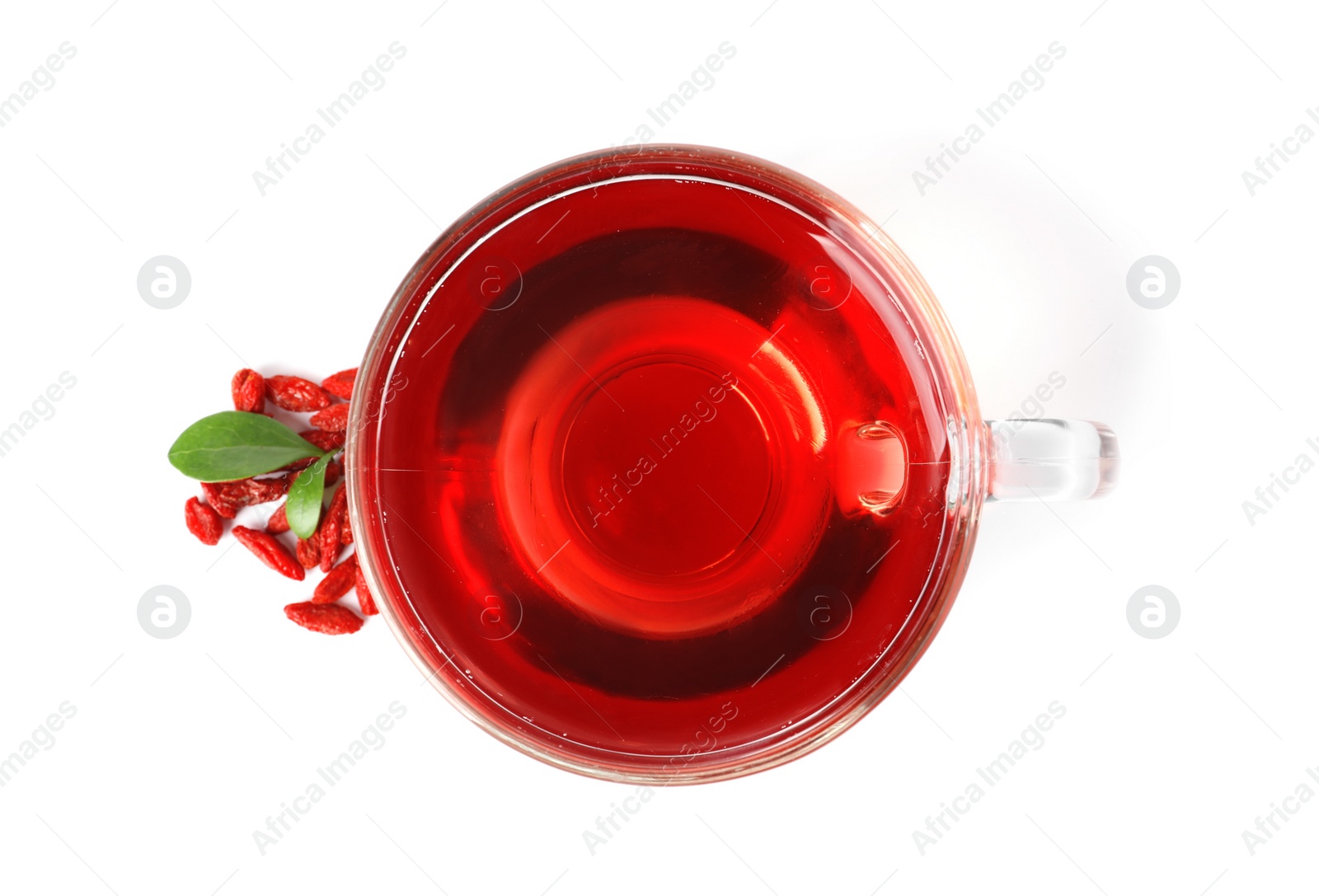 Photo of Healthy goji tea in glass cup with berries on white background, top view