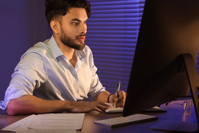 Tired young man working late in office