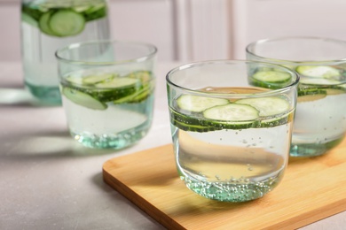 Photo of Glasses of fresh cucumber water on table. Space for text