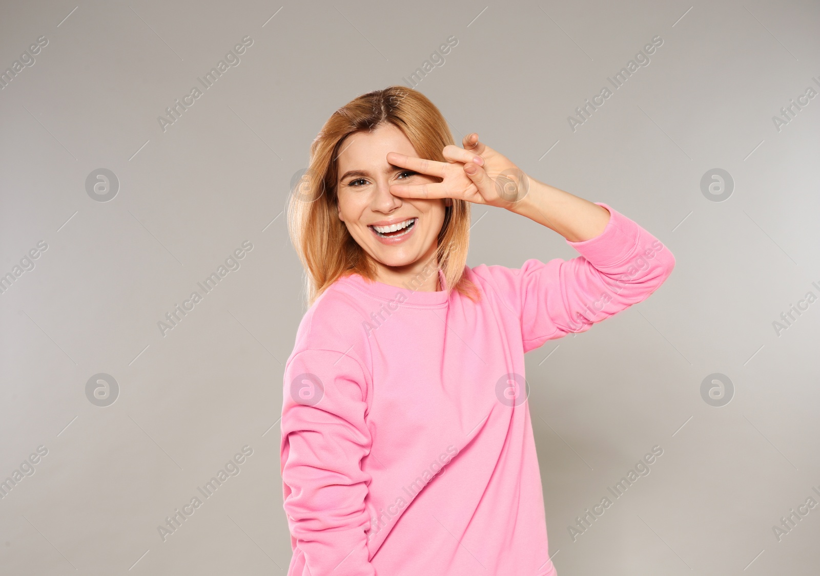 Photo of Portrait of positive woman posing on grey  background