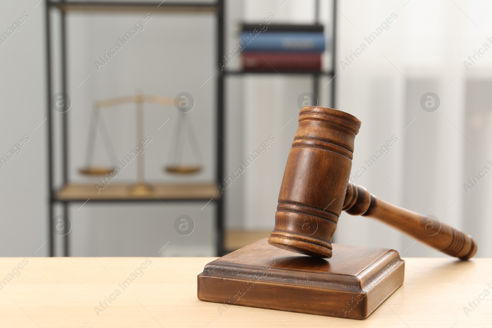 Photo of Wooden gavel and sound block on table indoors, closeup. Space for text