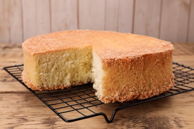 Photo of Tasty sponge cake on wooden table, closeup