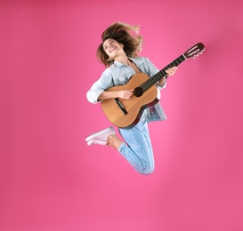 Photo of Young woman playing acoustic guitar on color background