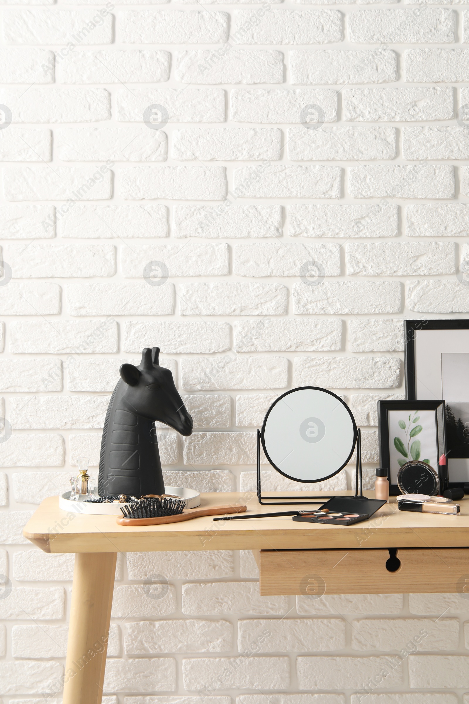 Photo of Dressing table with mirror, makeup products and accessories in room. Space for text