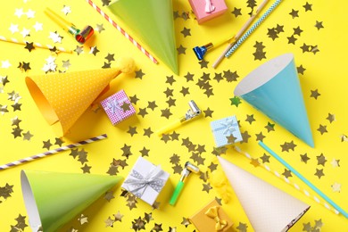 Flat lay composition with party hats on yellow background