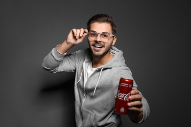 MYKOLAIV, UKRAINE - NOVEMBER 28, 2018: Young man with Coca-Cola can on dark background