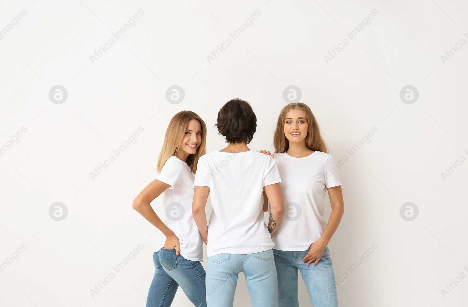 Photo of Group of young women in jeans on light background