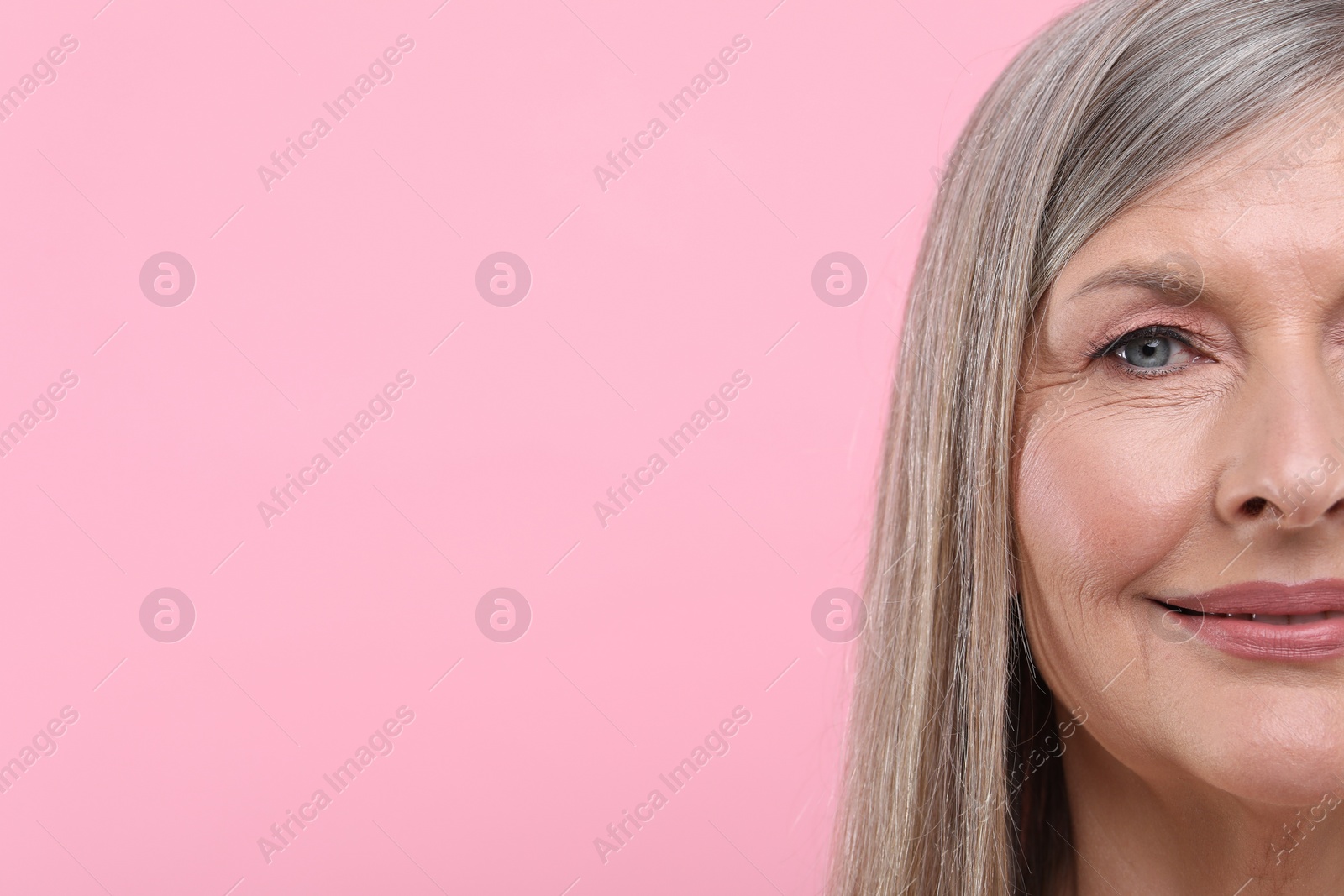 Photo of Portrait of beautiful senior woman on pink background, closeup. Space for text