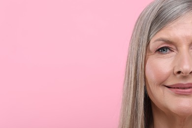 Photo of Portrait of beautiful senior woman on pink background, closeup. Space for text