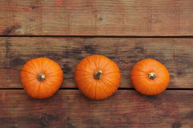 Photo of Fresh ripe pumpkins on wooden table, flat lay