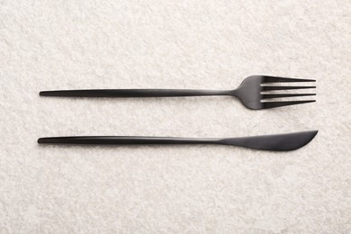 Photo of Stylish cutlery on beige textured table, top view