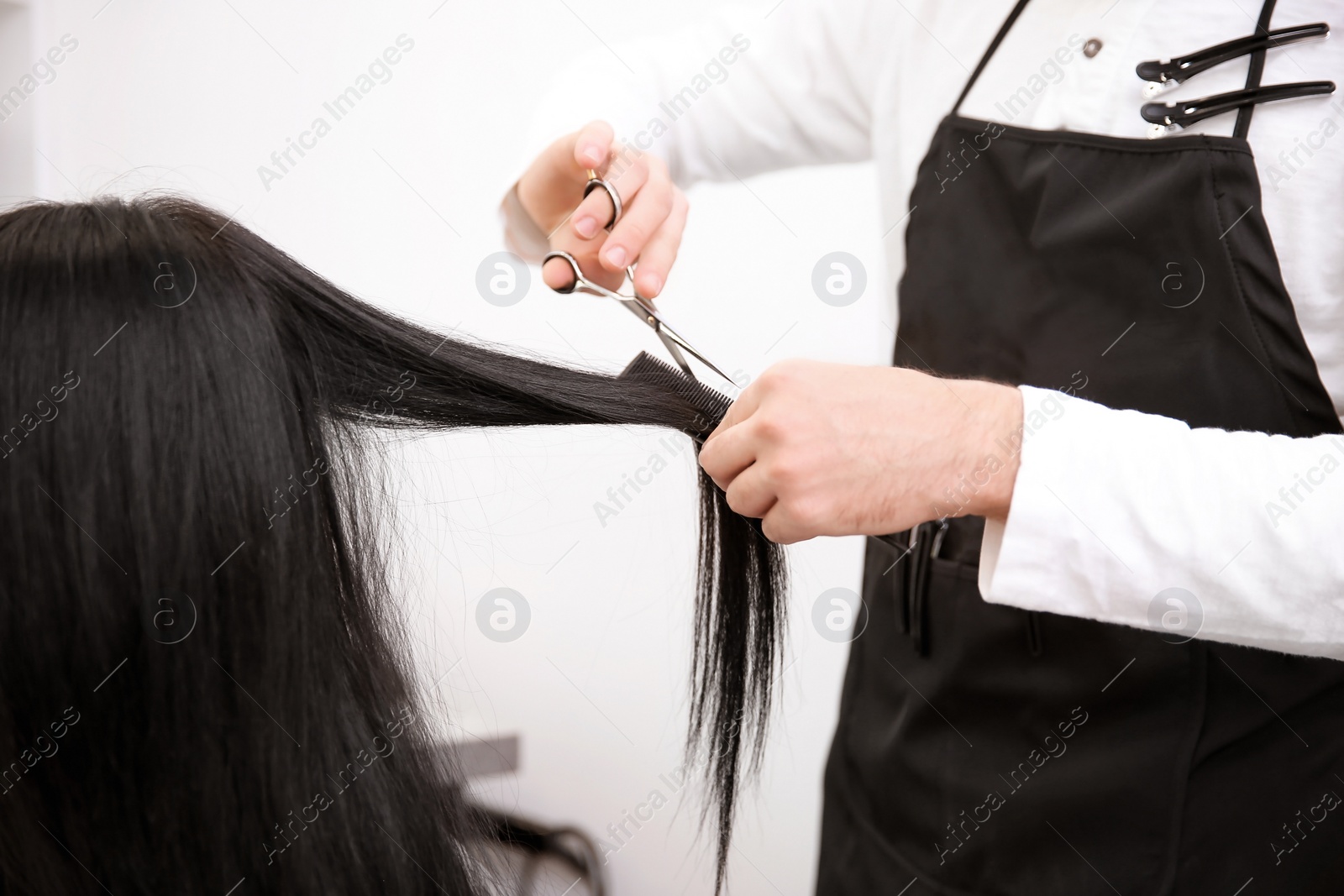 Photo of Professional male hairdresser working with client in salon