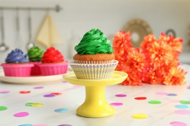 Photo of Delicious cupcake with green cream on white table