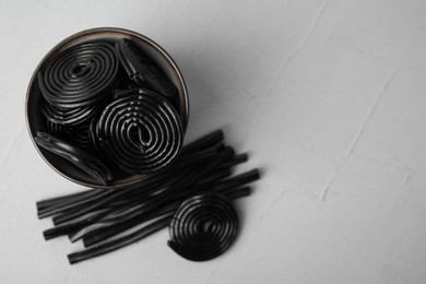 Photo of Tasty black liquorice candies on grey table, flat lay. Space for text